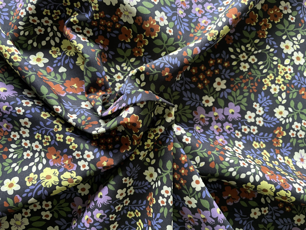 A beautiful ditsy floral Cotton Marlie-Care Lawn digital print in tones of Lavender, Maroon, Ivory and Fern Green on a Black background.