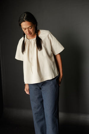 Sandra is wearing the Clover top in a light seersucker, size small and the 101 trousers in Tumbled Linen Fenn 160.