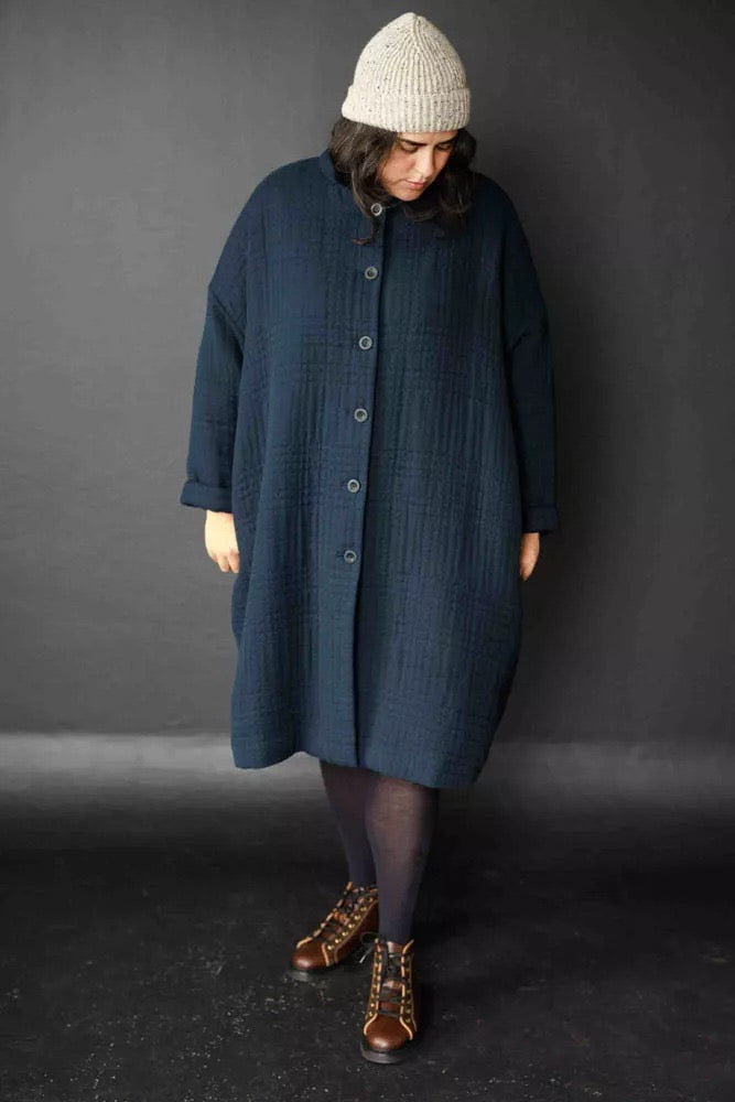 Larli is wearing the Sanda coat in Jacquard Cotton Soft Stitch Navy. Larli is a size 20, and is wearing a size 20. Larli is 5.10. 