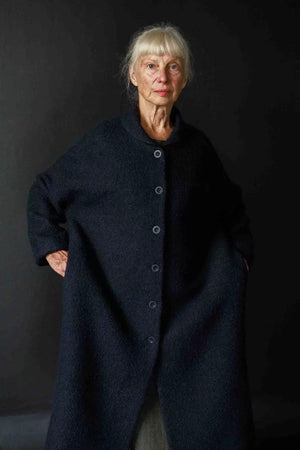 Judy is wearing the Sanda coat in a navy boucle wool, now out of stock. Judy is a 10 - 12, and is wearing a size 12. Judy is 5.6. 
