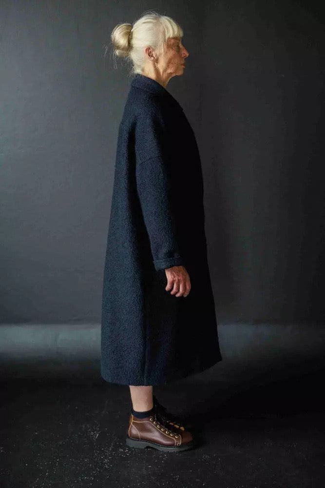 Judy is wearing the Sanda coat in a navy boucle wool, now out of stock. Judy is a 10 - 12, and is wearing a size 12. Judy is 5.6. 