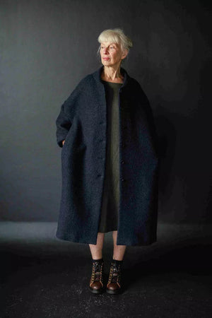 Judy is wearing the Sanda coat in a navy boucle wool, now out of stock. Judy is a 10 - 12, and is wearing a size 12. Judy is 5.6. 