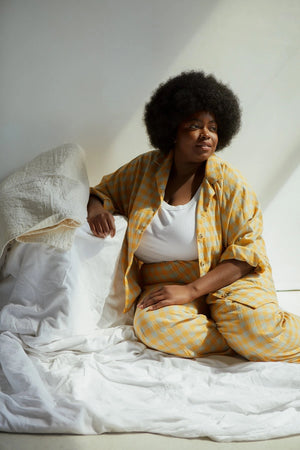 
                
                    Load image into Gallery viewer, Joy-ann (Black Afro hair wearing the orange and grey cotton lawn check PJs) Measurements: She is 5&amp;#39;9&amp;quot; tall 57&amp;quot;/50.5&amp;quot;/55.5&amp;quot; She is wearing a size 28 in both garments. 3 inches of length were added to the hem of her trousers but no other adjustments were made to the pattern.
                
            