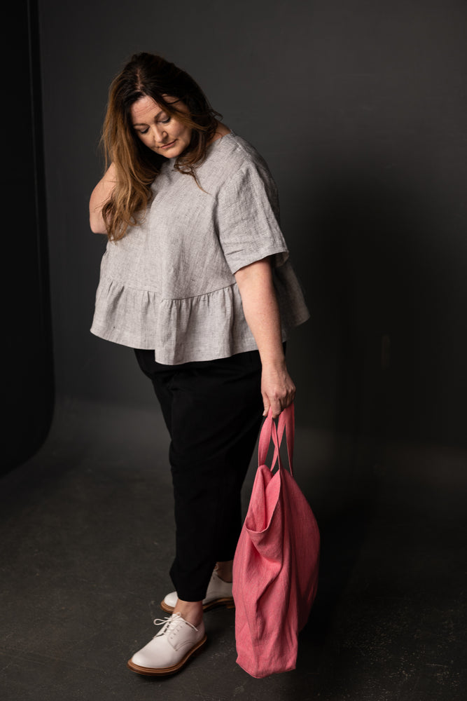 Claire is wearing the Florence top made in Spot Check with Eve trousers in 12oz Organic Twill Black. The bag is our Orton bag in Andy Pink.  Claire is a UK size 26.  